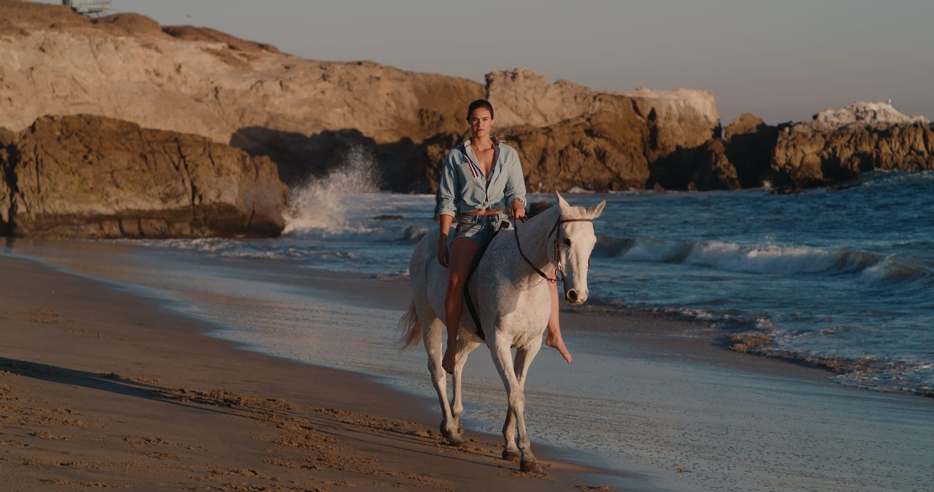 Horseback rider on the beach at sunset